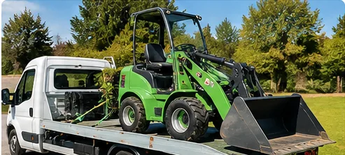 Engin compact chargé sur un plateau de dépanneuse VL